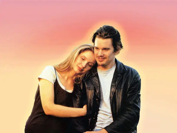 Couple embracing against warm-coloured sunset sky.