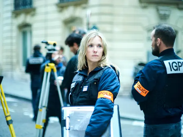 Blonde woman in blue police uniform standing next to man in IGPI vest.