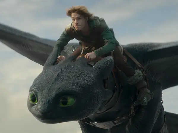 Hiccup the Viking, a white teenage boy with brown hair wearing a green outfit riding a large black dragon.