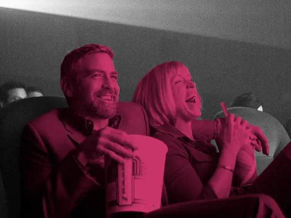 Two people laughing whilst holding popcorn in cinema seats, image tinted pink and magenta with grey background.